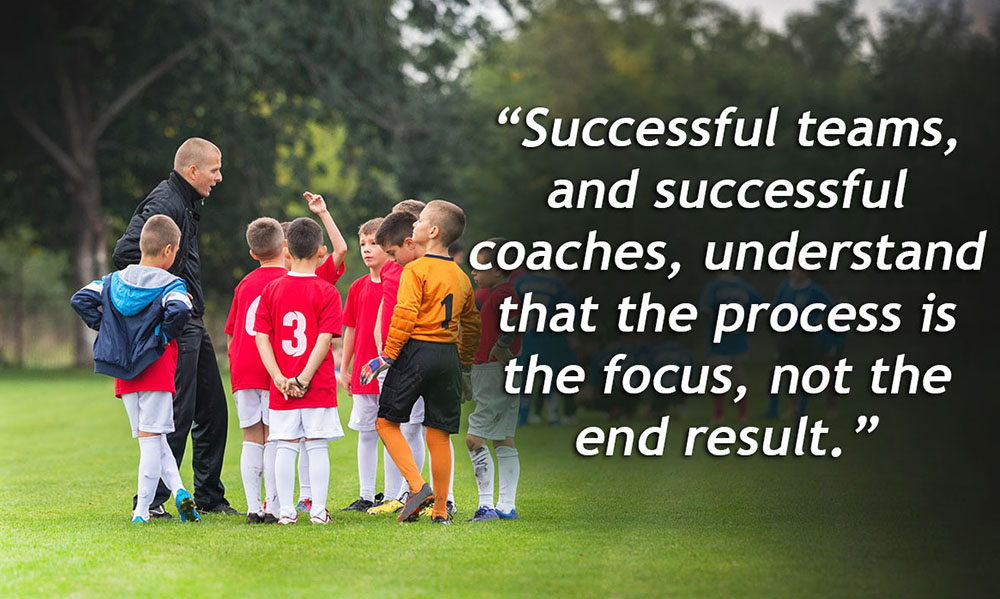 A good youth soccer coach talking to his team